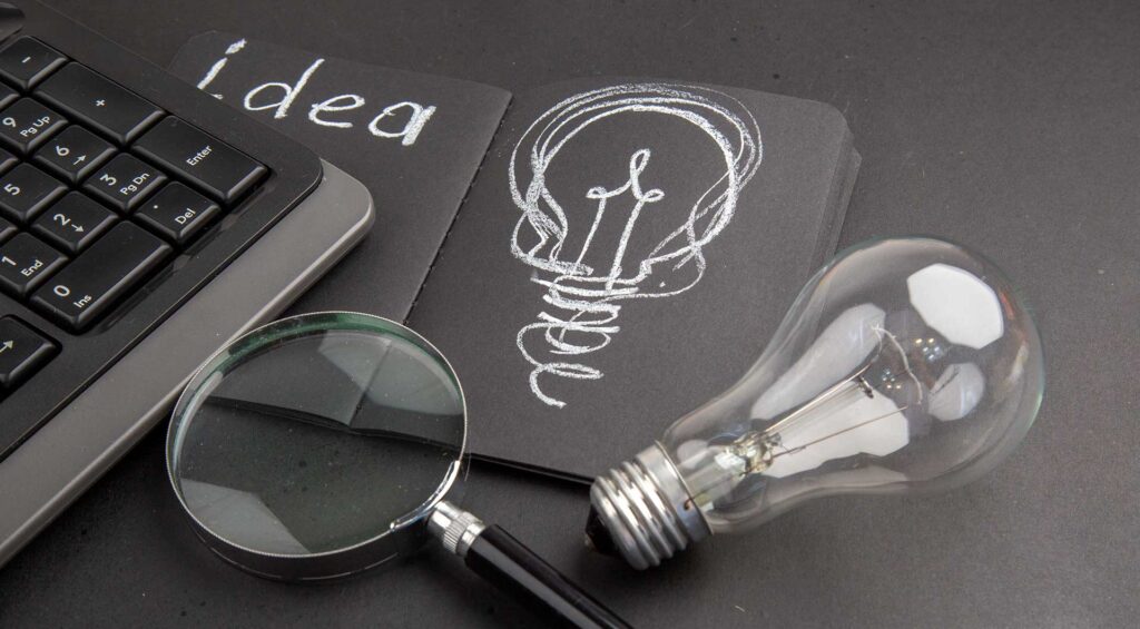 Non-competition & Intellectual Property Practice representation with lightbulb, magnifying glass and keyboard