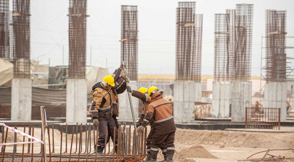 4 men wearing hard hats on a Construction site